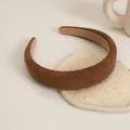 Close-up of brown corduroy sponge headband with non-slip interior on ceramic tray - Brown