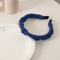 Detailed close-up of blue chunky knit sponge headband with textured weave and black ends - Knitted Yarn Dark Blue