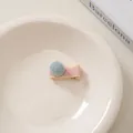 Nahaufnahme einer rosa gestreiften Haarspange mit hellblauem Bommel auf einem Teller - 21# Blaues Quadrat Rosa Basis