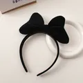 Detail view of the plush black velvet bow on a minimalist and elegant headband for women - Black
