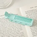Mint green hair root clip with comb teeth on a book for natural hair volume - Green