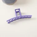Détail d'une grande pince à cheveux violet mat au design courbé élégant avec ressort métallique - Linéaire