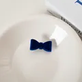 Dunkelblauer Samt-Haarclip mit Schleife für Damen mit weicher Textur auf weißem Teller - Blau