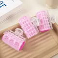 Detail of three pink self-grip hair rollers with transparent clips on a minimalist tray - Rose Pink