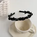 Detail of French vintage black headband with white stitched mini bows on ceramic plate - Black