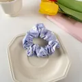 Close-up of lavender floral scrunchie with white daisy patterns on a ceramic plate - Lavender