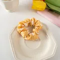 Detail eines gelben Blumen-Scrunchies auf Dekoteller mit frischem Tulpen-Hintergrund - 3# Gelb