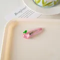 Detalle de la pinza para el pelo con melocotón rosa translúcido en bandeja crema - Clip BB Melocotón