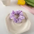 Detail of light purple floral scrunchie with daisy print on a decorative white plate - Mauve