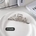 Gros plan d'une pince à cheveux argentée de 11cm avec texture ondulée métallique - Métal Irrégulier-Argent
