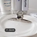 Détail d'une pince à cheveux argentée de 11,5cm avec décor cœur sur un plateau céramique - Cœur Double Face-Argent