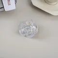 Vue détaillée d'une pince à cheveux fleur de rose transparente avec ressort doré - Transparent