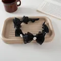 Close-up of black mesh bow headband with crystal on a ceramic tray in a cozy scene - Black