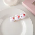 Détail de trois lapins 3D blancs avec des fraises sur une pince à cheveux dorée - Pince à Bec de Canard Lapin Blanc