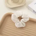 White seersucker scrunchie with crinkle texture on a tray for bun hairstyles - White