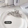 Détail macro d'une pince à cheveux papillon en métal liquide argenté de 10cm poli - Papillon Creux-Or Blanc