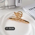 Vue détaillée de la pince à cheveux papillon dorée de 11,5 cm avec finition miroir poli - Papillon Simple Croisé-Or