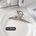Détail macro d'une pince à cheveux papillon argentée de 11,5 cm en métal poli - Papillon Simple Croisé-Argent