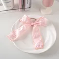 Fiocco per capelli a quadretti rosa e bianchi su piatto di ceramica e sfondo sobrio - Elastico Per Capelli Con Nastro N. 33 - Rosa
