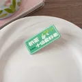 Détail d'une épingle en acrylique vert thé au lait sur une assiette en céramique - Amateur De Thé Au Lait N°1