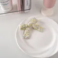Dettaglio di un dolce fermaglio per capelli a fiocco floreale su un piatto di ceramica - 15# Motivo Floreale Piccolo - Giallo
