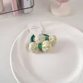 Dettaglio di elastici per capelli floreali con stampe blu e gialle su piatto di ceramica - Un Paio Di Elastici Per Capelli Floreali Taglia 50 - Verde Scuro