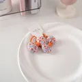 Dettaglio di elastici per capelli con fiocchi floreali in cotone su cartoncino - Un Paio Di Elastici Per Capelli Floreali N. 47 - Arancioni