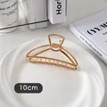 Détail d'une pince à cheveux en métal doré de 10 cm avec design ajouré sur assiette - Demi-cercle Mince-Or