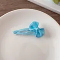 Primer plano de una horquilla con lazo azul claro en un plato de cerámica y fondo de madera - Azul
