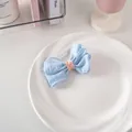 Dettaglio di un fermaglio per capelli a fiocco a quadretti blu e bianchi con maglia rosa - Griglia A Doppio Strato N. 18 - Blu