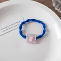Detail of blue spiral elastic hair tie featuring a cute pink 3D rabbit resin charm - Square Rabbit / Klein Blue