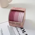 Detalle de gomas de pelo degradadas rosa de alta elasticidad en una caja de regalo - Cerezo de Primavera