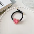 Détail d'un élastique à cheveux cœur rose avec effet œil de chat sur assiette blanche - Élastique Coeur Noir (5)