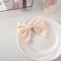 Dettaglio di un fiocco per capelli in raso color crema su un piatto bianco pulito - Nastro Di Cotone Largo N. 23 - Beige