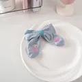 Dettaglio del fermaglio a fiocco azzurro con cigno rosa ricamato e corona dorata - 38# Cigno - Blu