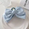 Primer plano de una pinza para el cabello con lazo doble de satén azul claro decorativa - Azul Crema
