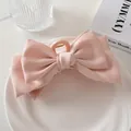 Detalle de pinza para el pelo con lazo de satén rosa multicapa en una bandeja blanca - Rosa crema
