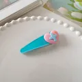 Detail van een pastelkleurige haarklem met roze hart op een wit decoratief bord - Blauw-Harten