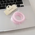 Close-up of pink matte spiral hair ties set on a silver laptop background with packaging - One Glossy And One Frosted / 2 Pcs/Set / Pink Series