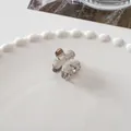 Detailed close-up of a mini silver metal flower hair claw clip on a decorative ceramic tray - Small Flower Silver