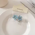 Dettaglio di mini mollette per capelli a fiori blu con strass su scheda accessori - Molle / Blu