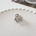 Close-up of a mini silver metal bow hair claw clip on a decorative pearl plate - Princess Bow - Silver