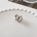 Detailed close-up of a heart-shaped silver metal hair claw clip on a pearl-edged white plate - Heart - Silver