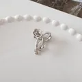 Polished silver metal butterfly hair claw clip resting on a white ceramic plate - Ribbon Bow - Silver