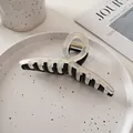 Détail d'une grande pince à cheveux bicolore noir et beige sur une assiette décorative - Noir Transparent Contraste-Style Croisé