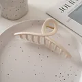 Grande pince à cheveux crème avec ressort doré posée sur une assiette en céramique - Blanc Transparent Contraste-Style Croisé