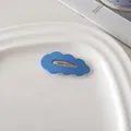 Dettaglio di un fermaglio per capelli a nuvola blu opaco su un vassoio di ceramica - Blu