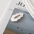 Dettaglio di un fermaglio per capelli BB ondulato bianco crema su una rivista - Bianco
