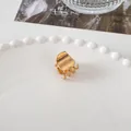 Close-up of a small golden metal hair claw clip displayed on a white jewelry plate - Mini Square Claw - Gold