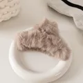 Dettaglio di un fermaglio per capelli in ecopelliccia color caffè su vassoio in ceramica - Grigio